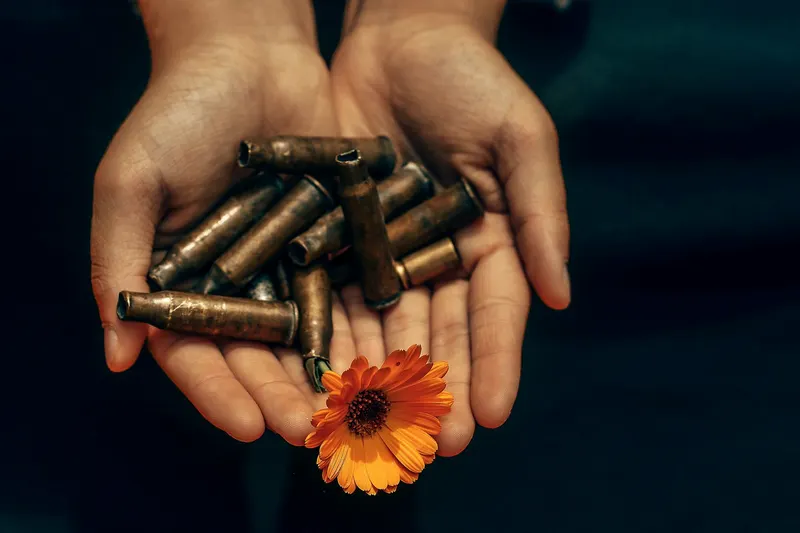 Hands holding a mix of spent brass cartridge cases
